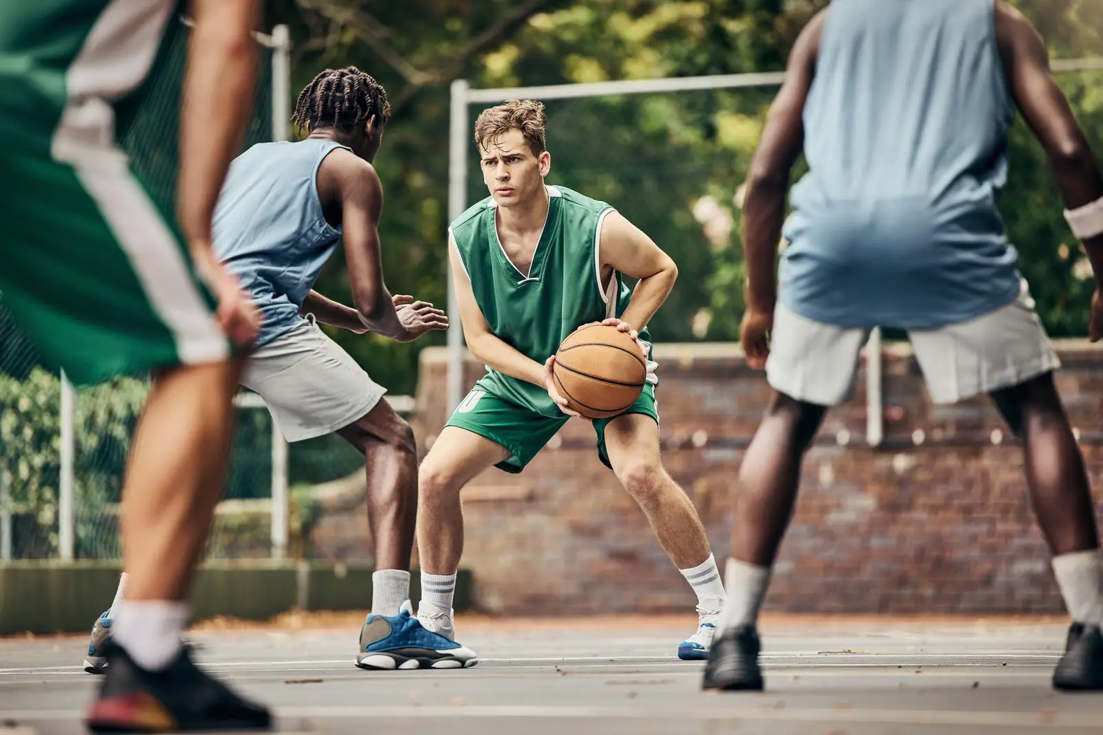 Basketball, team sport and competition for male athletes and players in training or professional match on an outdoor fitness court. Diversity, competitive and skill of men playing a ball game in USA